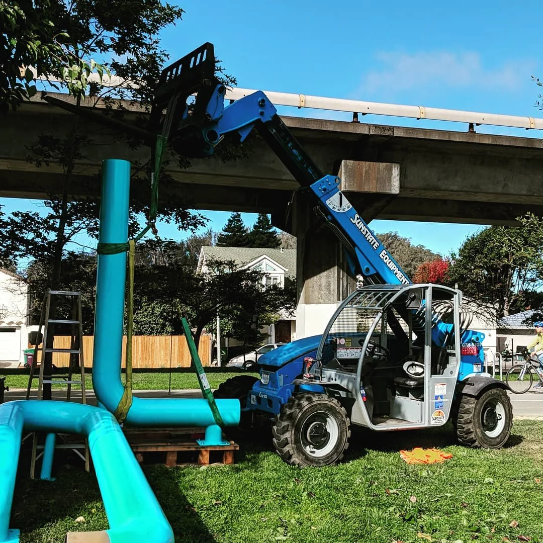 Telehandler positioning a large Albany Loop steel component during installation